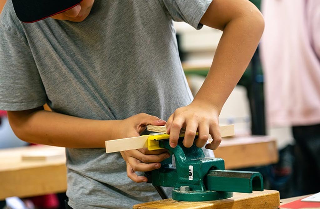 Jugendlicher bei der Arbeit mit Holz